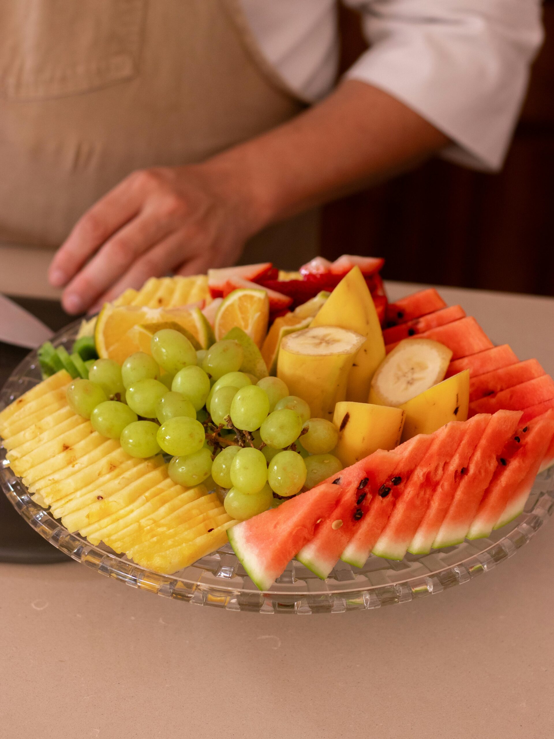 Vibrant fruit platter featuring watermelon, banana, grapes, and pineapple slices.